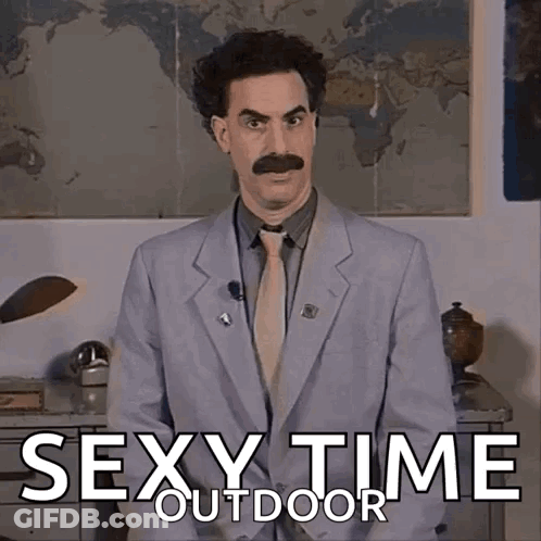 A Man In A Suit And Tie Is Standing In Front Of A Sign That Says Sexy Time Outside GIF
