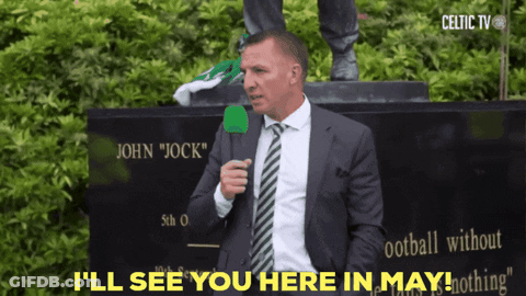 A Man In A Suit And Tie Is Standing In Front Of A Statue Of John Jock GIF