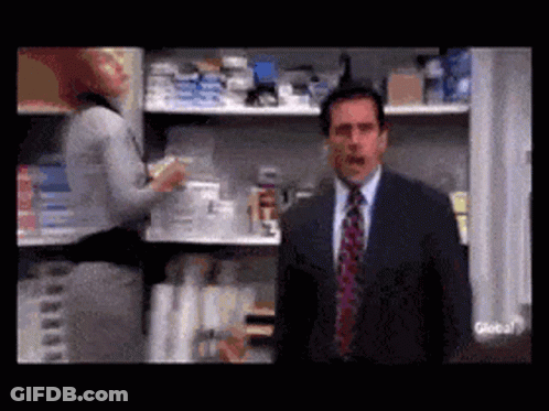 A Man In A Suit And Tie Is Standing In Front Of A Store Shelf . GIF