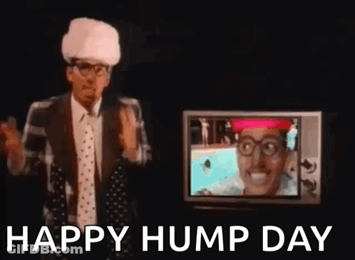 A Man In A Suit And Tie Is Standing In Front Of A Television And Waving His Hand . GIF