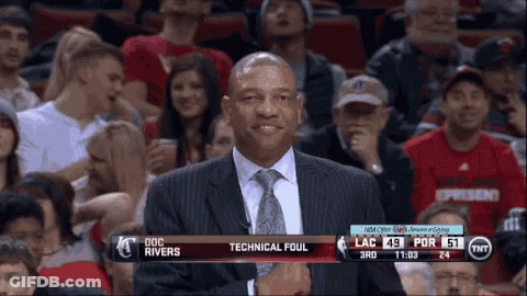 A Man In A Suit And Tie Is Standing In Front Of A Tnt Advertisement GIF