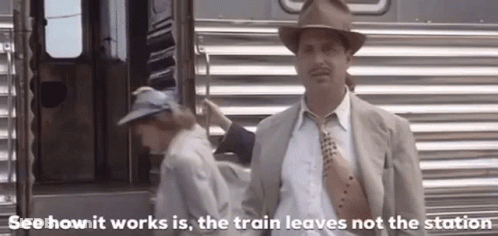 Man In Suit And Tie Standing In Front Of Train GIF