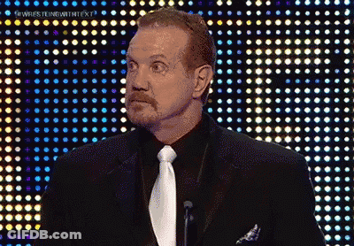 A Man In A Suit And Tie Is Standing In Front Of A Wall Of Lights GIF