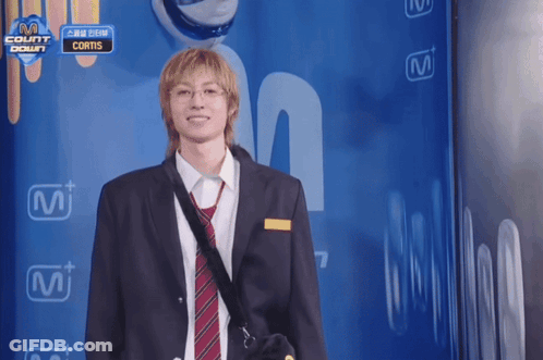 A Man In A Suit And Tie Is Standing In Front Of A Wall That Says " Count Down " GIF