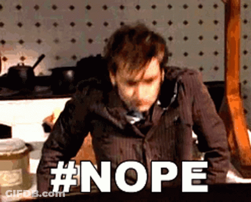 A Man In A Suit And Tie Is Standing In Front Of A Wall That Says Nope GIF