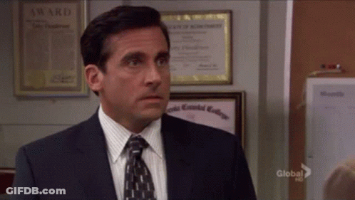 A Man In A Suit And Tie Is Standing In Front Of A Wall With A Certificate That Says Award On It GIF