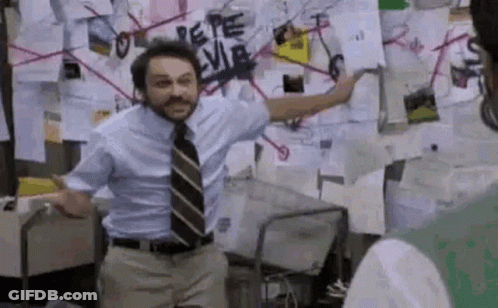 A Man In A Suit And Tie Is Standing In Front Of A Wall With Papers On It . GIF
