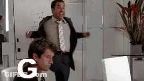 A Man In A Suit And Tie Is Standing In Front Of A White Board With The Letter G On It GIF