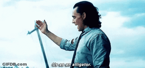 A Man In A Suit And Tie Is Standing In Front Of A Windmill And Talking . GIF