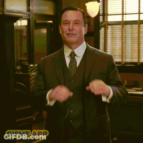 A Man In A Suit And Tie Is Standing In Front Of A Window In An Office . GIF