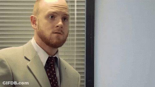 Man In Suit And Tie In Front Of Blinds GIF