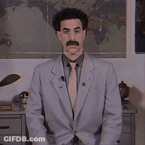 A Man In A Suit And Tie Is Standing In Front Of A World Map GIF