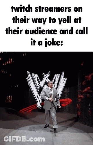 A Man In A Suit And Tie Is Standing In Front Of A Wwe Logo GIF