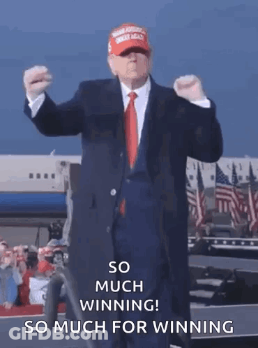 A Man In A Suit And Tie Is Standing In Front Of An Airplane . GIF