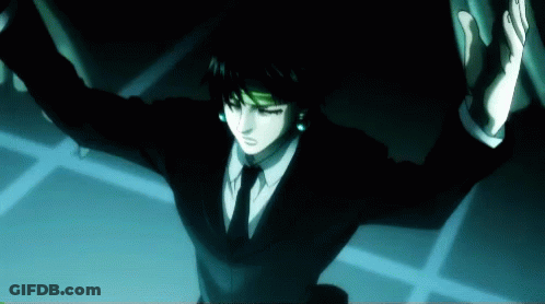 A Man In A Suit And Tie Is Standing In The Dark With His Arms Outstretched GIF