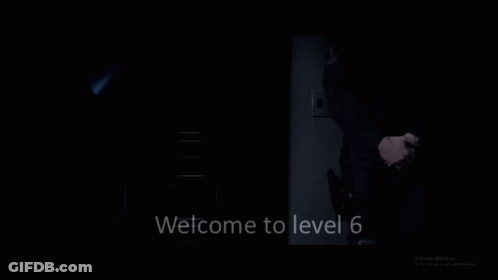 A Man In A Suit And Tie Is Standing In The Dark With The Words Welcome To Level 6 Below Him GIF