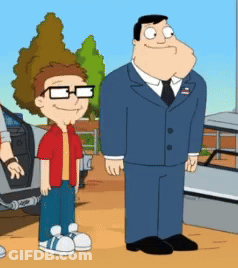 Man In Suit Standing Next To Boy With Glasses GIF