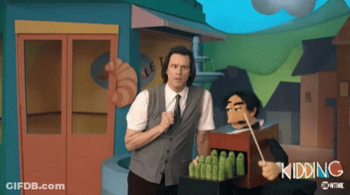 A Man In A Suit And Tie Is Standing Next To A Puppet With The Word Kidding Written On It GIF