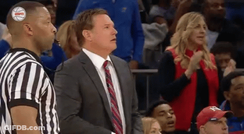 A Man In A Suit And Tie Is Standing Next To A Referee GIF