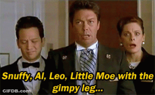 A Man In A Suit And Tie Is Standing Next To A Woman And A Man In A Bow Tie GIF