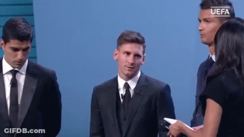 A Man In A Suit And Tie Is Standing Next To A Woman Holding A Microphone While Two Other Men Stand Behind Him . GIF