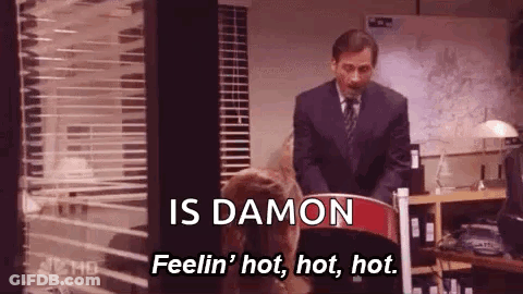 A Man In A Suit And Tie Is Standing Next To A Woman In A Chair And Talking To Her . GIF
