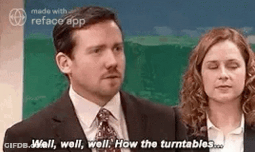 A Man In A Suit And Tie Is Standing Next To A Woman In A Suit And Tie . GIF
