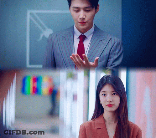 A Man In A Suit And Tie Is Standing Next To A Woman In A Suit GIF