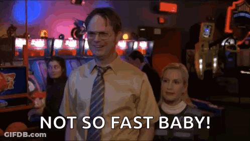 A Man In A Suit And Tie Is Standing Next To A Woman In An Arcade And Says `` Not So Fast Baby '' . GIF