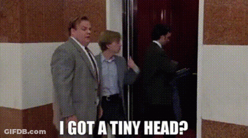 A Man In A Suit And Tie Is Standing Next To A Woman In An Elevator And Says I Got A Tiny Head ? GIF