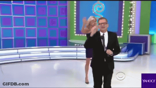 A Man In A Suit And Tie Is Standing Next To A Woman On A Stage With A Yahoo Logo In The Corner GIF