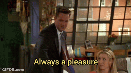 A Man In A Suit And Tie Is Standing Next To A Woman Who Is Sitting On A Couch . GIF