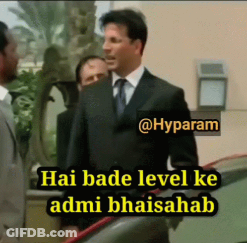 A Man In A Suit And Tie Is Standing Next To Another Man And Says Hai Bade Level Ke Admibhaisahab GIF