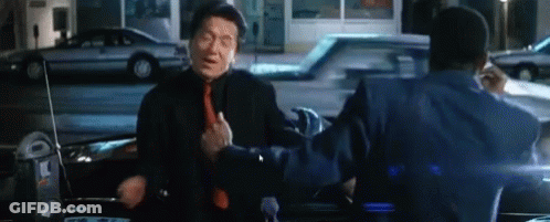 A Man In A Suit And Tie Is Standing Next To Another Man In A Car . GIF