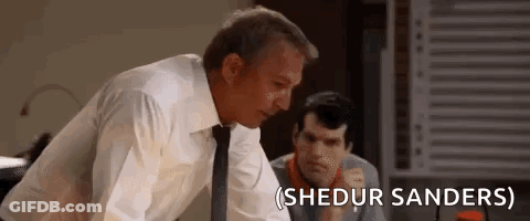 A Man In A Suit And Tie Is Standing Next To Another Man In A Room . GIF