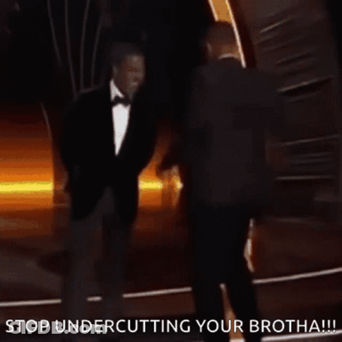 A Man In A Suit And Tie Is Standing Next To Another Man In A Suit And Tie And Says Stop Undercutting Your Brotha GIF