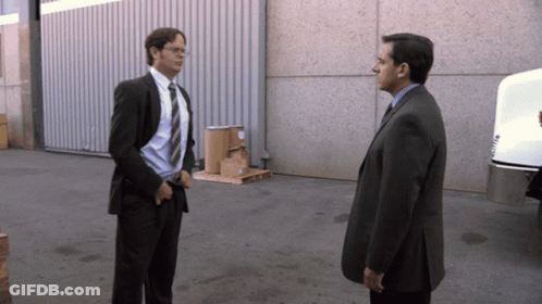 A Man In A Suit And Tie Is Standing Next To Another Man In A Suit GIF