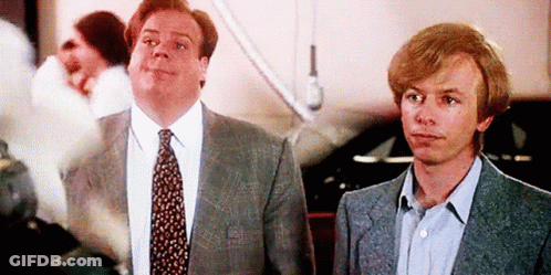 A Man In A Suit And Tie Is Standing Next To Another Man GIF