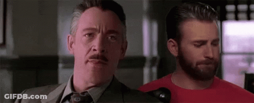 A Man In A Suit And Tie Is Standing Next To Another Man With A Beard . GIF