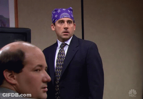 A Man In A Suit And Tie Is Standing Next To Another Man With A Nbc Logo On The Bottom Right GIF