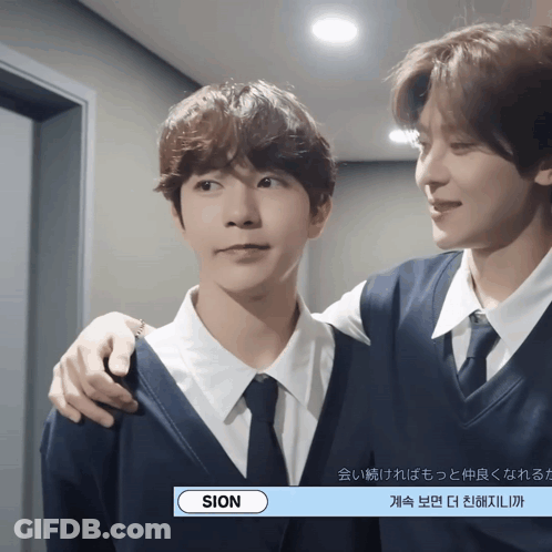 A Man In A Suit And Tie Is Standing Next To Another Man GIF