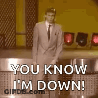 A Man In A Suit And Tie Is Standing On A Stage . GIF