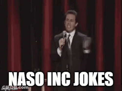 A Man In A Suit And Tie Is Standing On A Stage Holding A Microphone And Saying Naso Inc Jokes . GIF