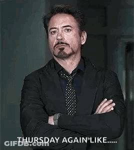 A Man In A Suit And Tie Is Standing With His Arms Crossed And A Beard . GIF