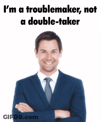 A Man In A Suit And Tie Is Standing With His Arms Crossed And Says I 'M A Troublemaker Not GIF