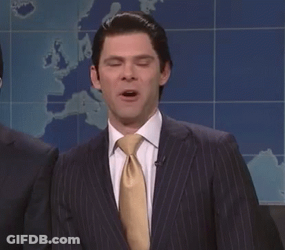 A Man In A Suit And Tie Is Standing With His Eyes Closed . GIF