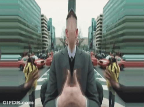 A Man In A Suit And Tie Is Surrounded By Buildings GIF