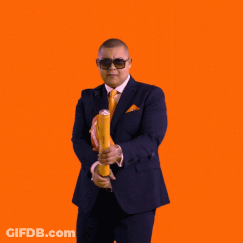 A Man In A Suit And Tie Is Surrounded By Confetti And A Bag That Says Haas GIF