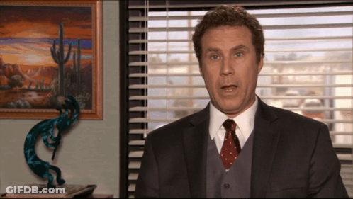 A Man In A Suit And Tie Is Talking In Front Of A Window GIF