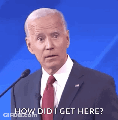 A Man In A Suit And Tie Is Talking Into A Microphone And Says How Did I Get Here GIF